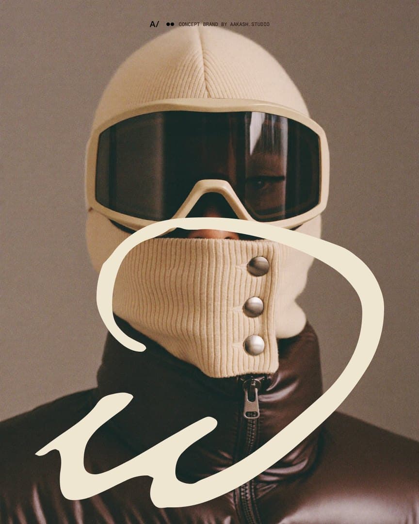 Carousel opener: the knit balaclava and its goggle full bleed, with the lowercase w drawn large in ecru around the snap gaiter.